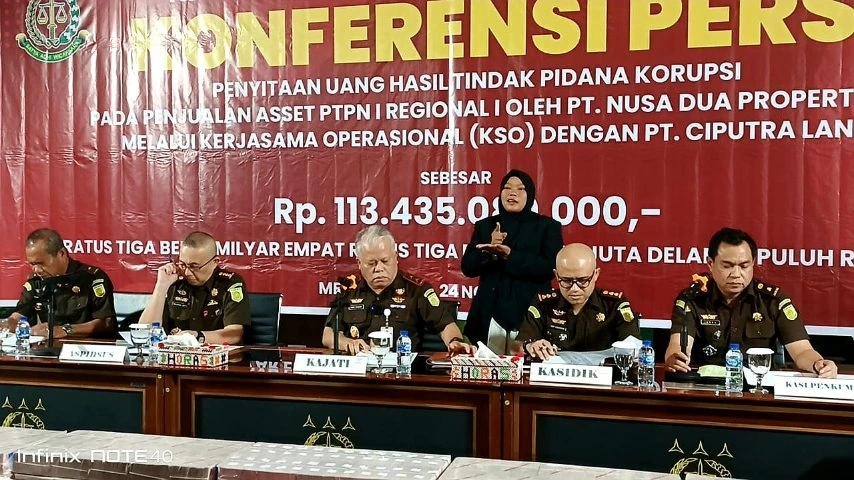 Pejabat Kejati Sumut menggelar konferensi pers mengenai pengembalian kerugian negara kasus penjualan aset PTPN I, dengan latar belakang banner besar berwarna merah.