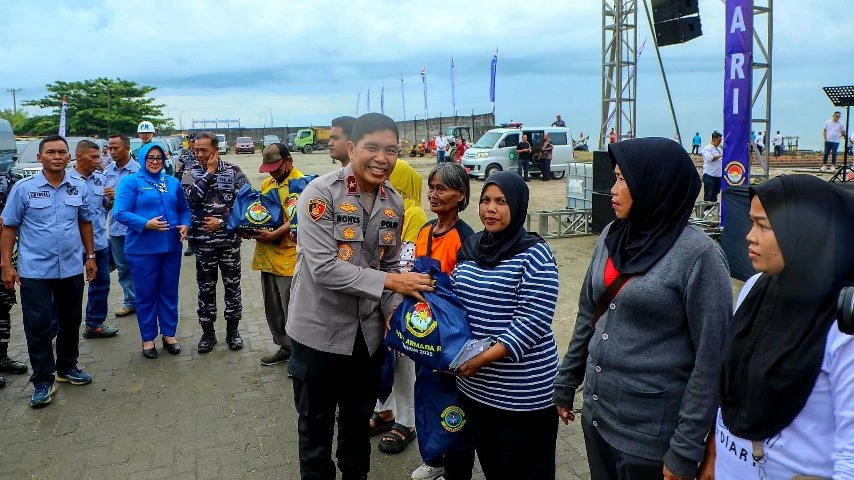 Wakapolda Sumut Brigjen Pol Rony Samtana menyerahkan paket bantuan sosial kepada warga Belawan dalam rangkaian kegiatan Bakti Kesehatan dan Bakti Sosial HUT Armada RI ke-80 di Dermaga 104 Belawan.