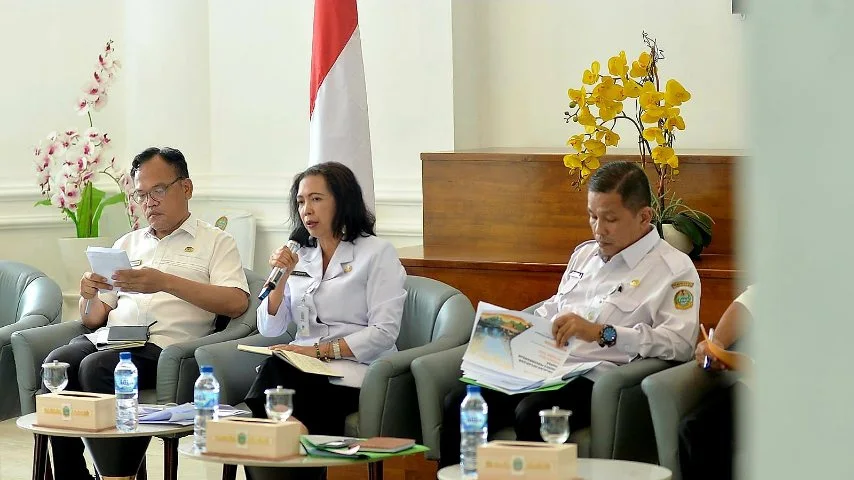 Tiga pejabat Pemprov Sumut mengikuti rapat pengendalian inflasi, salah satu pejabat perempuan berbicara menggunakan mikrofon di Kantor Gubernur Sumut.