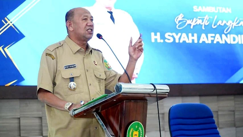 Bupati Langkat H. Syah Afandin menyampaikan sambutan di podium dalam sebuah acara resmi pemerintah daerah.