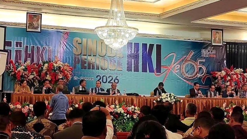 Suasana pembukaan Sinode HKI ke-65 tahun 2026 di Medan, terlihat pimpinan sidang duduk di meja utama dengan latar belakang spanduk besar bertuliskan Sinode HKI ke-65.