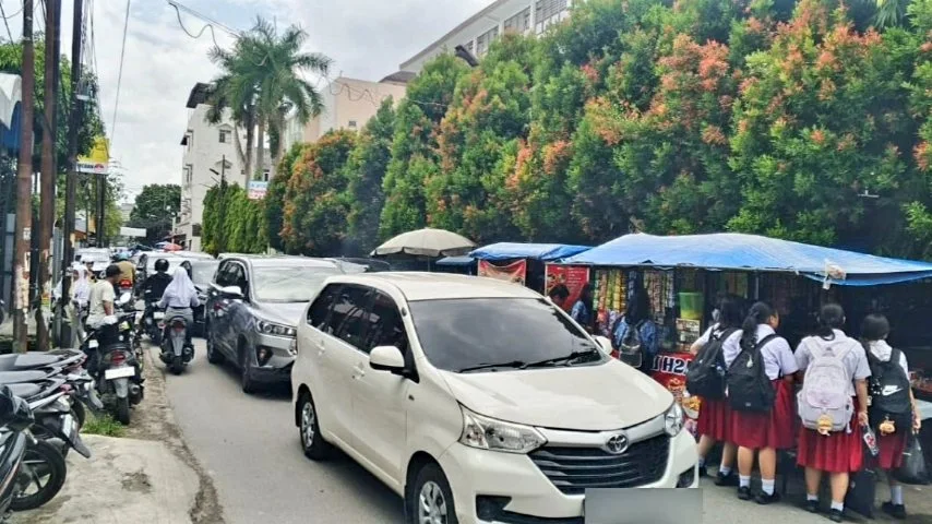 Kemacetan di Jalan Jambi Medan akibat parkir mobil berlapis dan aktivitas siswa di tepi jalan