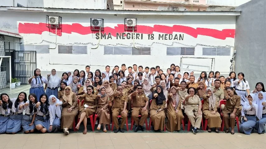 Siswa dan guru SMA Negeri 18 Medan berfoto bersama merayakan 58 siswa lolos SNBP 2026 di halaman sekolah