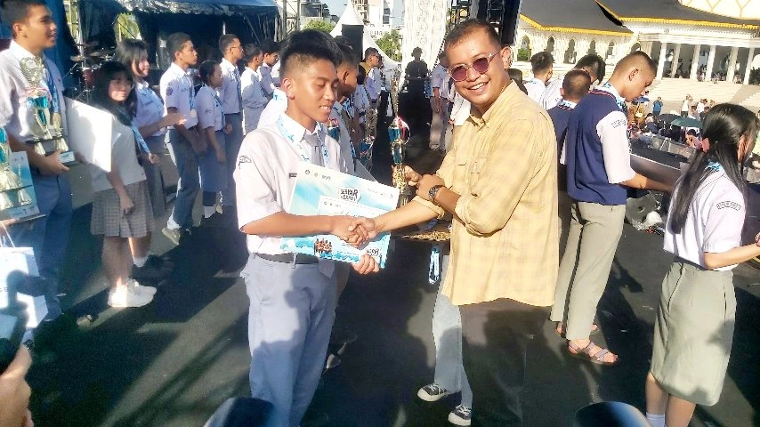 Kacabdis Wil. I, David Eltom Nainggolan menyerahkan piagam dan berjabat tangan dengan siswa pemenang lomba pada penutupan Expo Pendidikan Sumut 2026.
